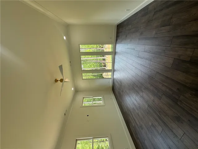 This expansive room features vaulted ceilings and rich wood flooring, offering abundant natural light.