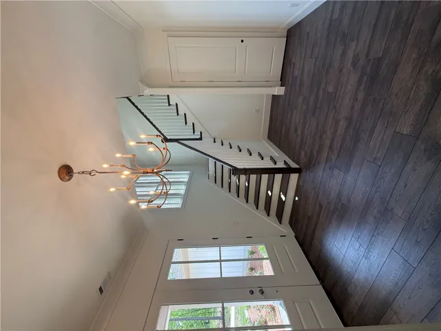 Enter into a bright foyer with rich hardwood flooring and a beautifully crafted staircase.