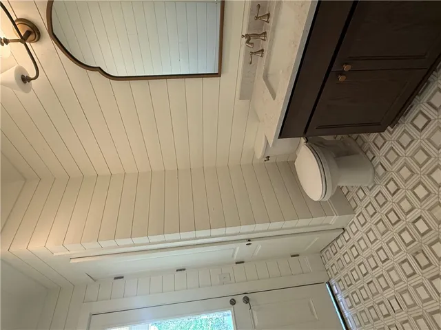 This bright bathroom features a stylish vanity and patterned tile flooring.