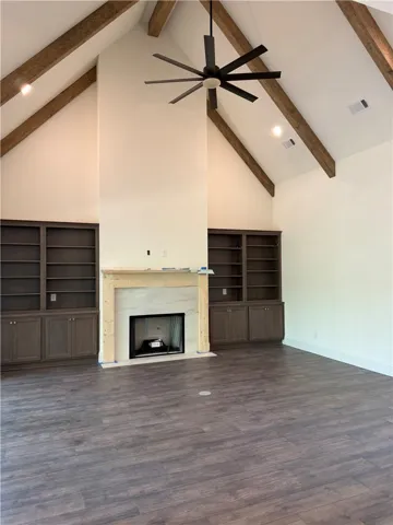This living room features vaulted ceilings with exposed beams and a modern fireplace.