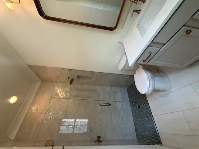 This bathroom features sleek tile work and a contemporary vanity with modern fixtures.