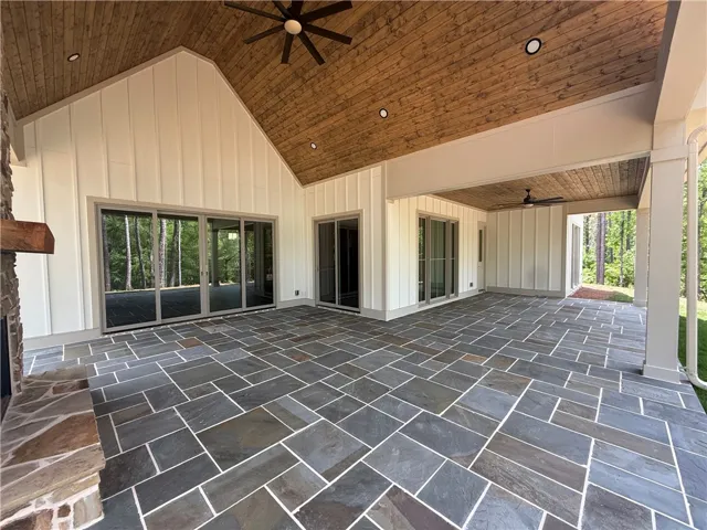 An inviting outdoor living area with a vaulted wooden ceiling and natural stone flooring.