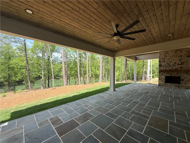This expansive patio provides an ideal setting for outdoor enjoyment, complete with a stone fireplace and picturesque water views.