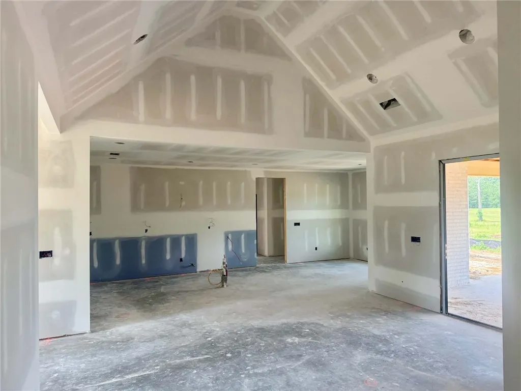 An inviting open-plan interior showcases dramatic vaulted ceilings and direct access to outdoor living.