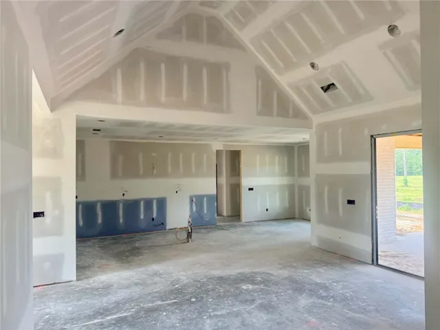 An inviting open-plan interior showcases dramatic vaulted ceilings and direct access to outdoor living.