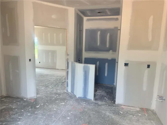 A new construction project awaits final touches, featuring fresh drywall ready for paint.