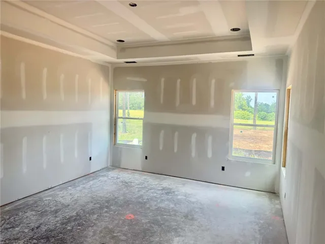 A new construction bedroom awaits personalization, featuring recessed lighting and a tray ceiling.