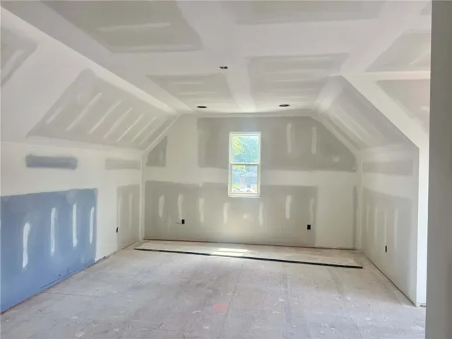 A well-lit, unfinished room with an angled ceiling awaits custom design possibilities.