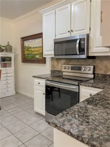 This kitchen features elegant cabinetry, modern appliances, and durable granite countertops.