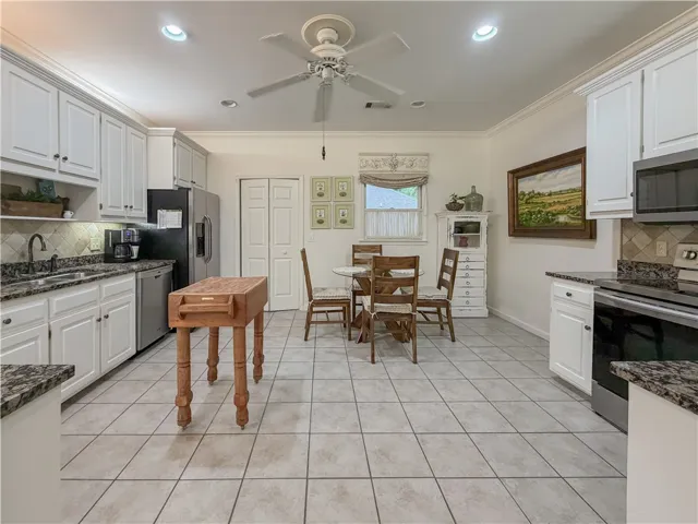 This spacious kitchen offers a functional layout, with ample cabinetry, and an inviting breakfast nook.