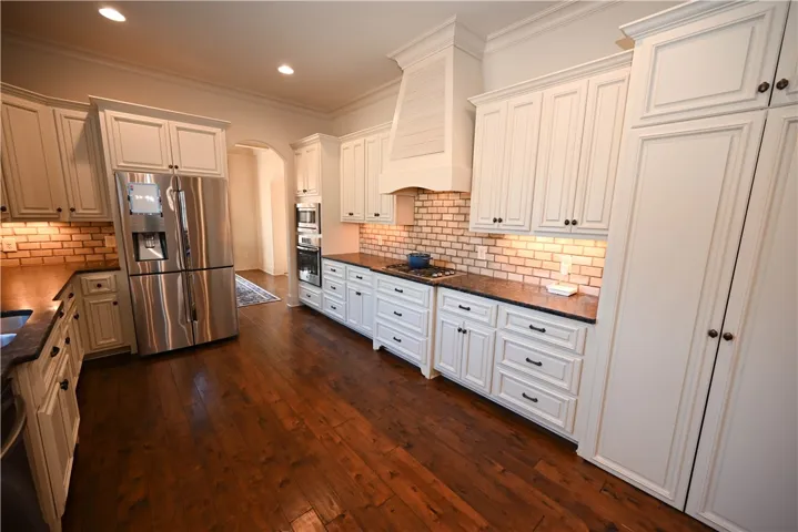Pristine white cabinetry with matching range hood.