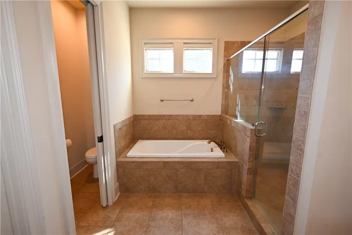 A soaking tub, tiled/glass shower, and large walk-in closet.