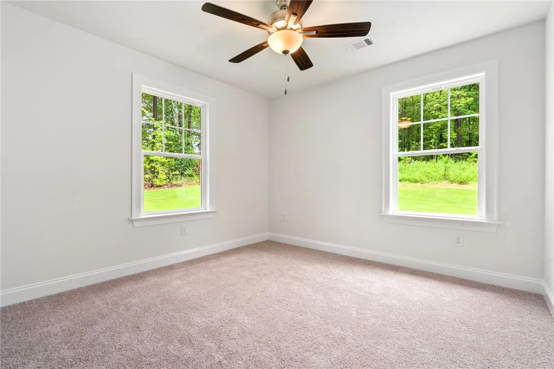 Well-lit and tranquil, this bedroom provides a serene retreat with views of nature.