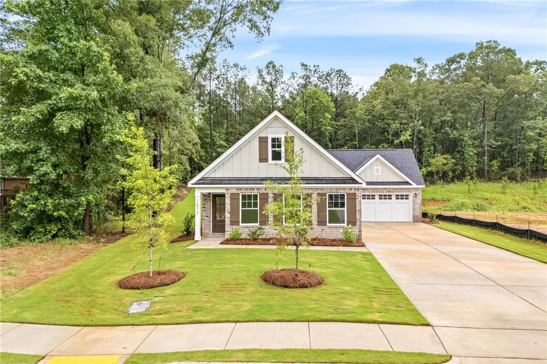 A charming single-family home with an attached garage and a neatly manicured lawn.