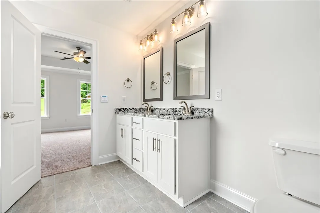 Double vanity with stone counters provides ample space in this refreshed primary bathroom.