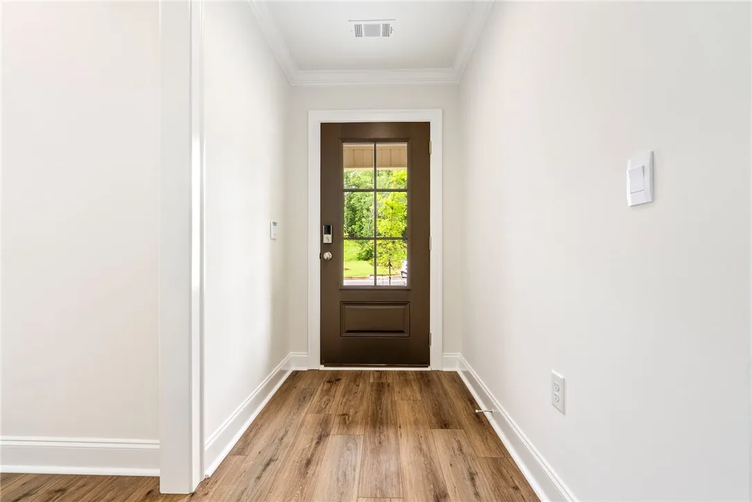 A welcoming entry hallway showcases beautiful hardwood flooring and crisp white walls.
