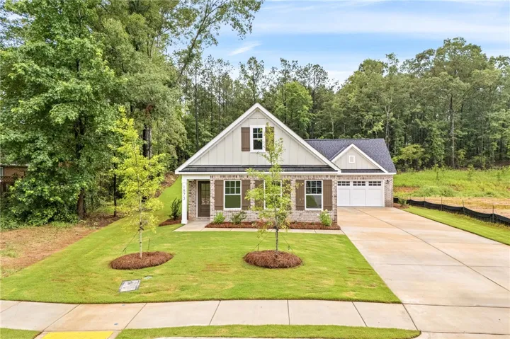 A charming single-family home with an attached garage and a neatly manicured lawn.