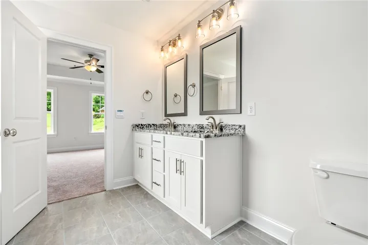 Double vanity with stone counters provides ample space in this refreshed primary bathroom.