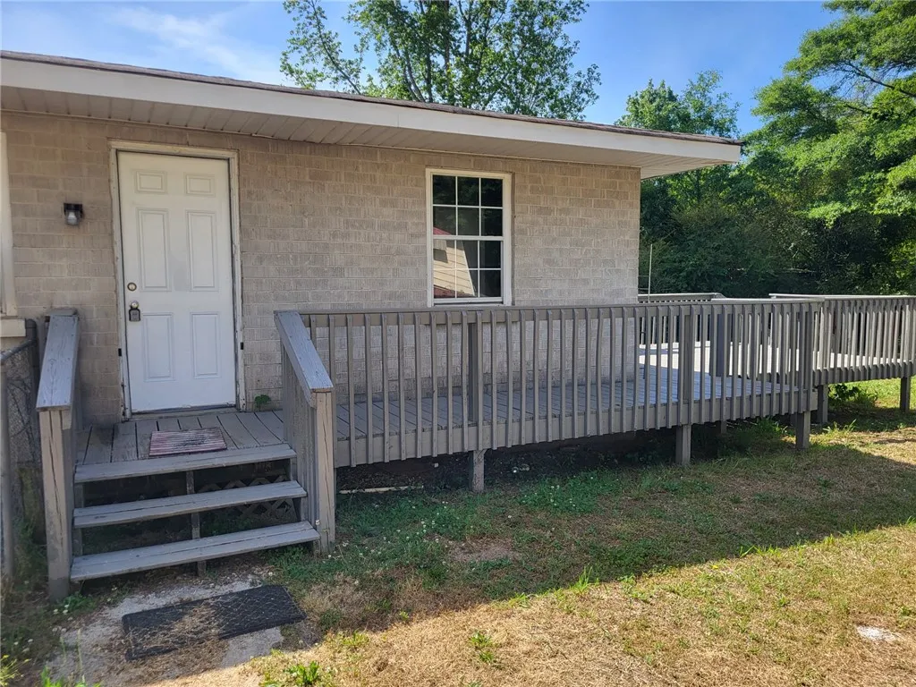 This residence features a large wooden deck, perfect for outdoor enjoyment and relaxation.