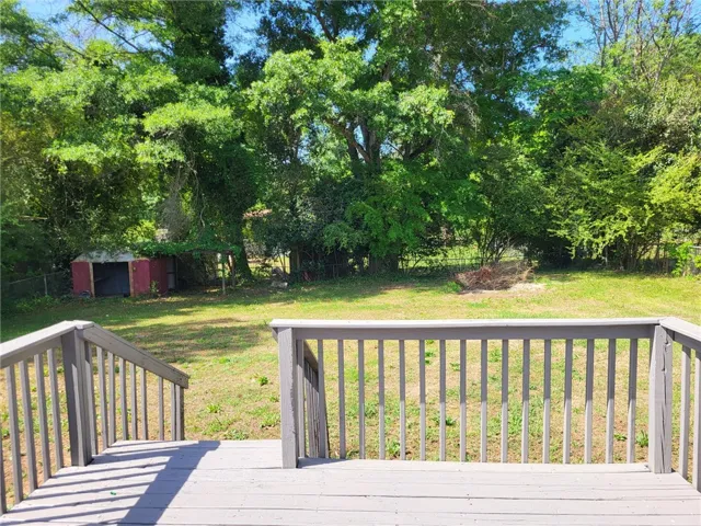 This spacious yard offers a vibrant green landscape and a versatile storage shed.