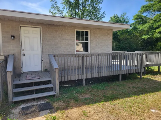 This residence features a large wooden deck, perfect for outdoor enjoyment and relaxation.