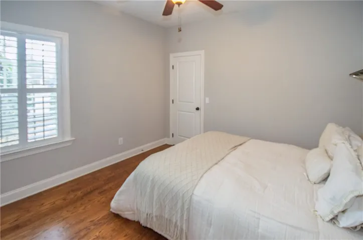 3rd bedroom with walk in closet and wood flooring