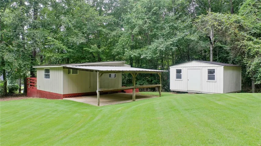 Back of Clubhouse with Carport & Storage Building