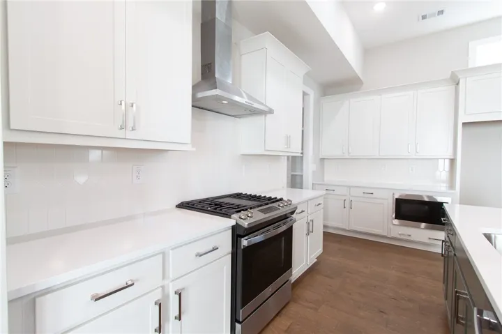 This modern kitchen features pristine white cabinetry and sleek, integrated appliances.