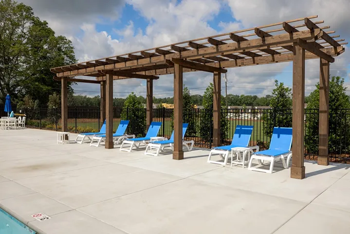 An inviting outdoor oasis awaits with a charming wooden pergola, perfect for relaxation by the pool.