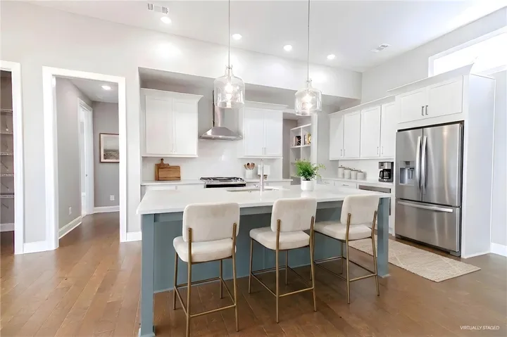 This bright kitchen features an island, ample counter space, and modern appliances for daily living.