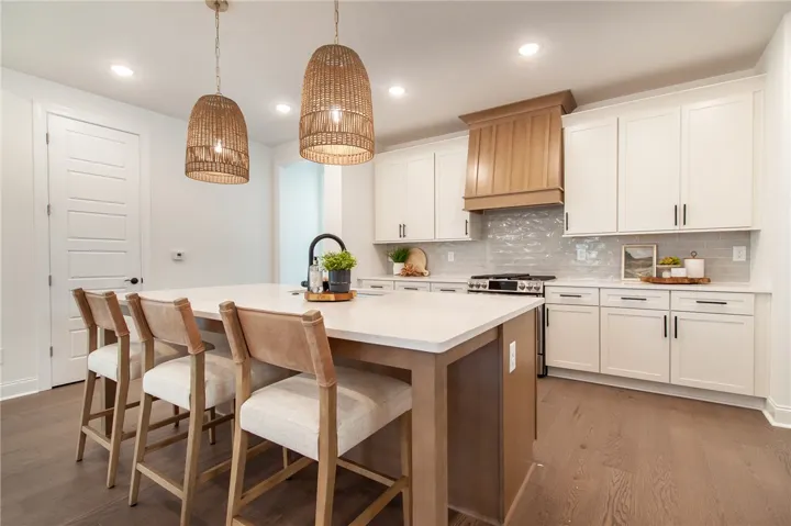 This bright kitchen features an expansive island with seating, ideal for gathering and culinary creations.