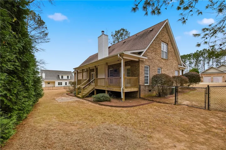 Fenced backyard with additional open yard beyond, offering plenty of room for play and outdoor activities.