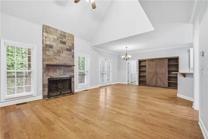 Two-story living room featuring a fireplace framed by windows.