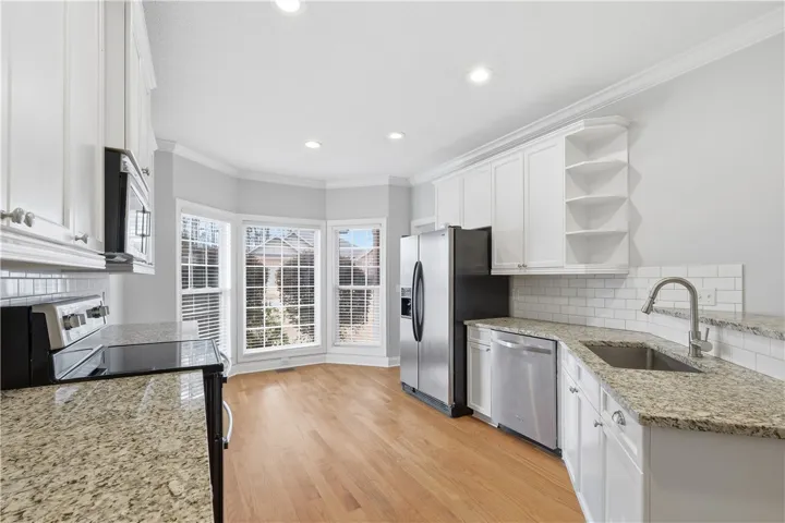 Breakfast nook framed by three windows, bringing in abundant natural light.