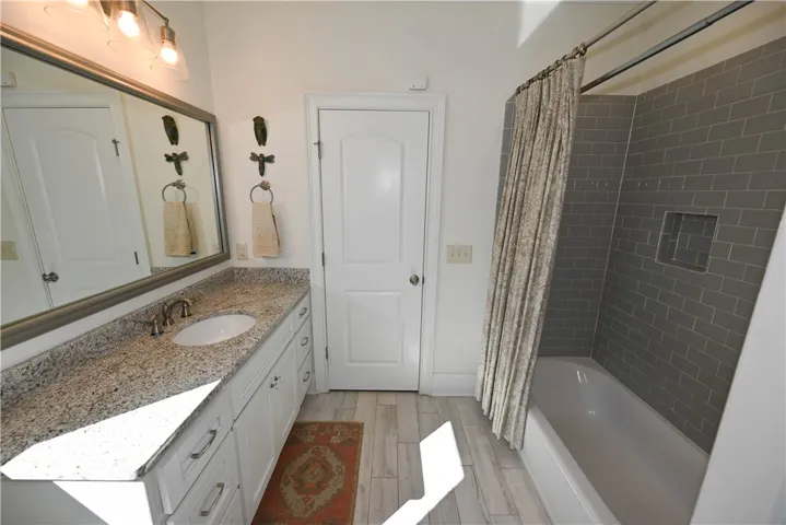 Full bath adjacent to bedroom 2 with a tub with tile surround.