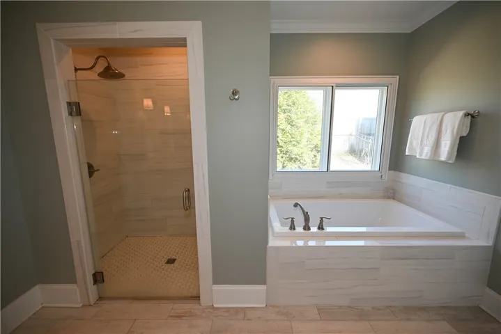 Zero entry tiled shower complete with niche, seat & frameless glass door.