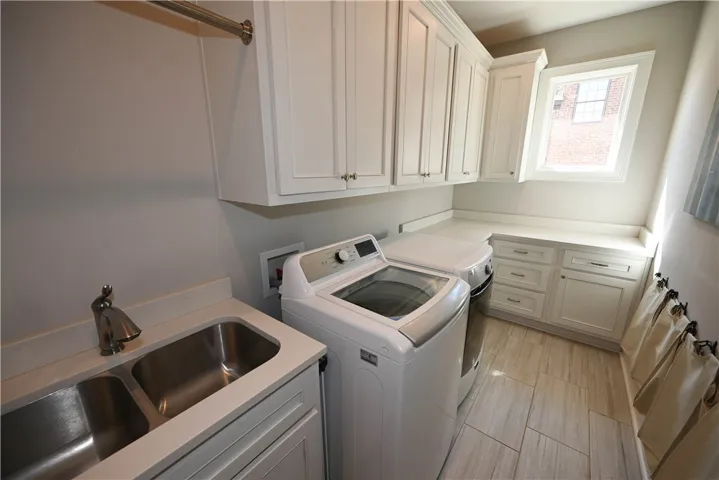 Lovely laundry room! Tons of cabinets, undermount sink and picture window