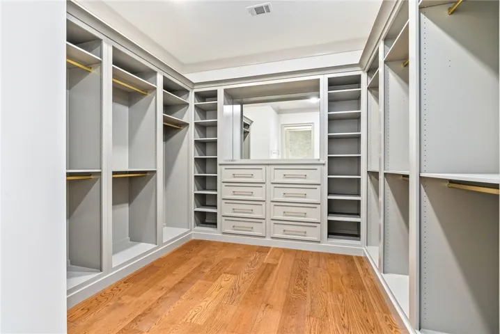 Ample storage solutions abound within this well-appointed closet, featuring built-in shelving and convenient drawers.