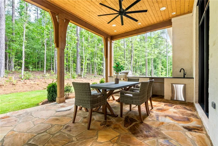An inviting covered patio offers tranquil woodland views, ideal for outdoor entertaining.