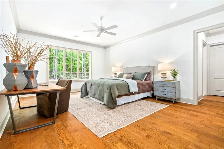 Hardwood floors and a verdant view define this tranquil primary bedroom.