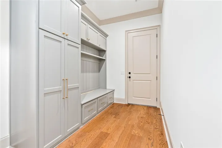 Streamlined built-in storage and gleaming hardwood floors create an inviting entry.