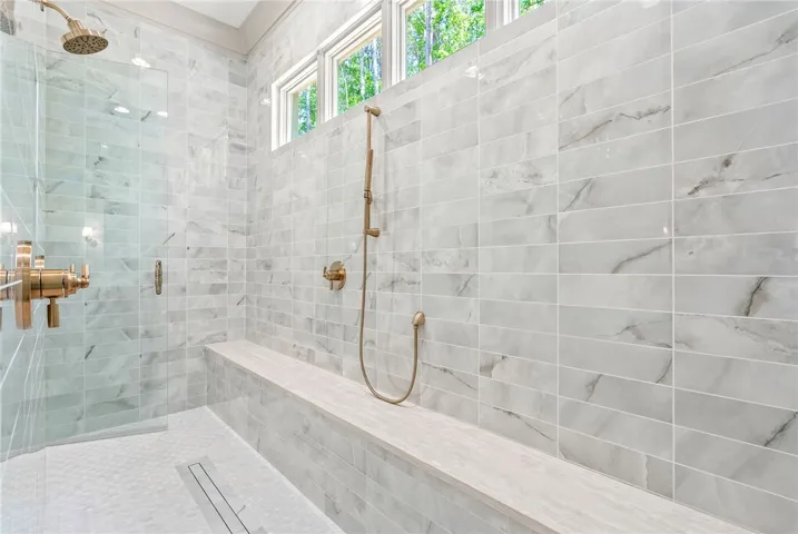 Stunningly tiled shower features a built-in bench, offering both elegance and practical comfort.