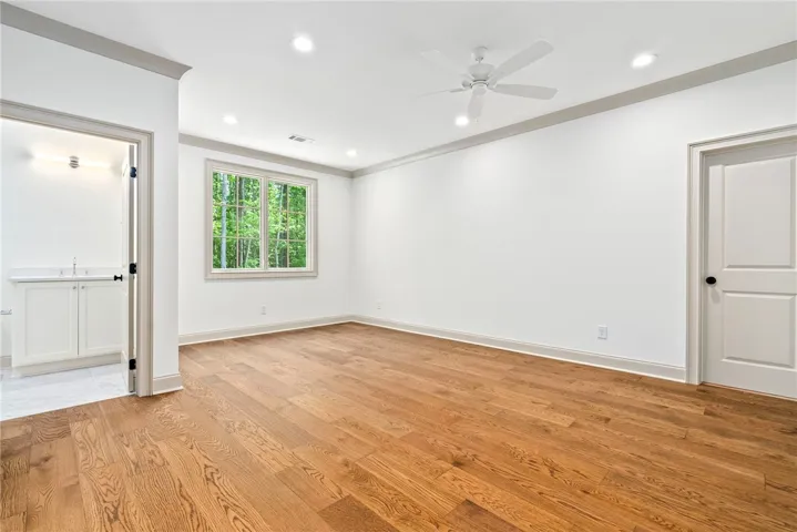 A tranquil retreat, this well-lit room boasts rich hardwood floors and verdant outdoor views.