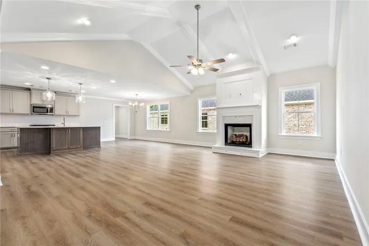 An open-concept living space with a contemporary kitchen and a prominent fireplace at its heart.