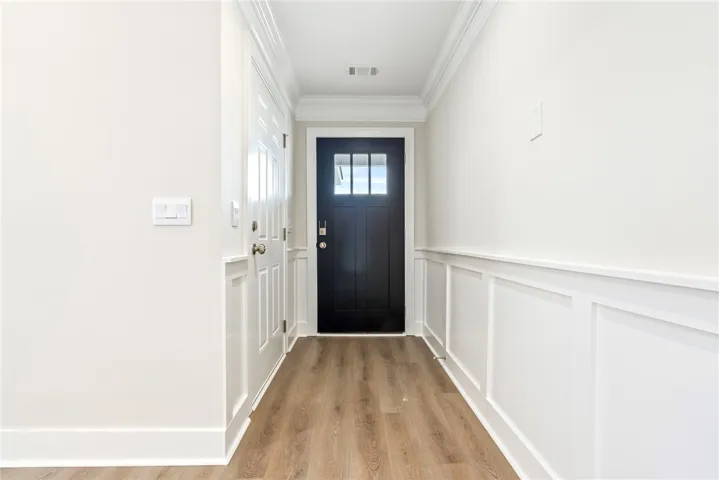 A welcoming entryway with refined wainscoting and durable hardwood flooring.