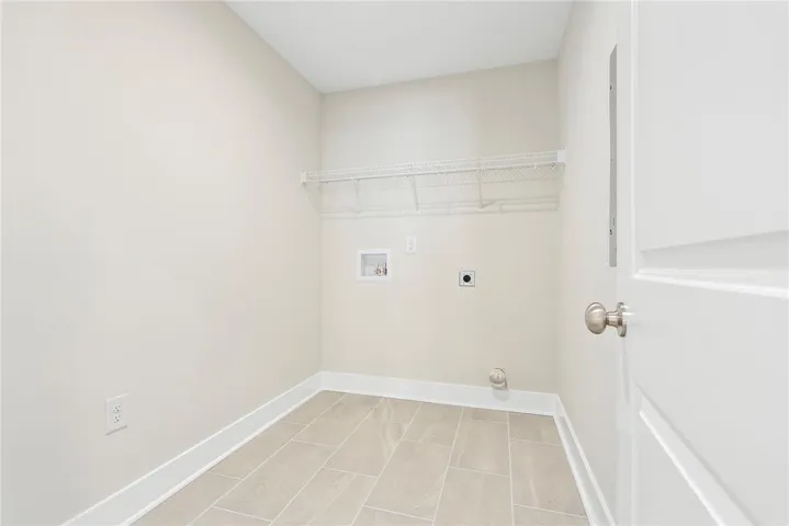A dedicated laundry room with convenient shelving and tiled flooring, ready for your appliances.