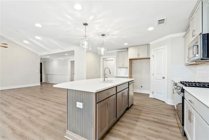 A well-lit kitchen with a spacious island connects seamlessly to a versatile living area.