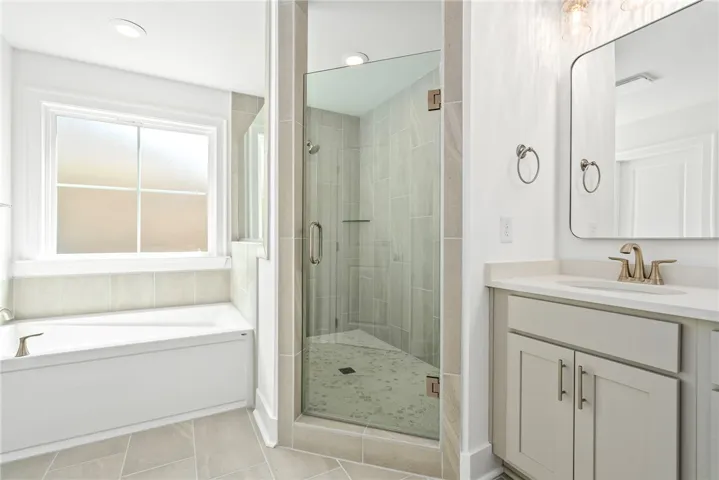 A well-appointed bathroom offers both a tiled walk-in shower and a built-in tub.