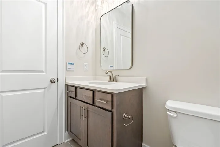 A sleek vanity with ample storage and a contemporary mirror anchors this bright bathroom.