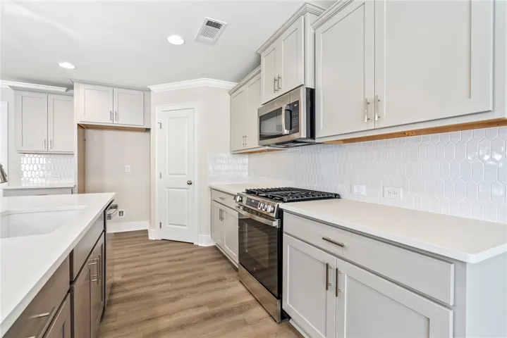 Modern kitchen with white countertops and light-colored cabinetry offers seamless meal preparation.